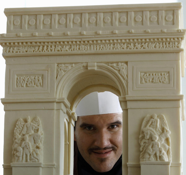 Italian chocolatier Mirco Della Vecchia poses with a chocolate sculpture of the Arc de Triomphe, as part of his &apos;Chocolate World Heritage&apos; exhibition in Hong Kong Jan 20, 2011. [China Daily/Agencies]