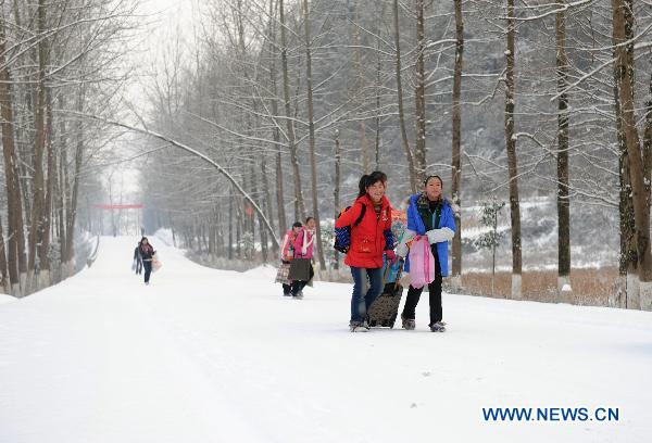 Students walk on their way back home as buses were canceled due to icy roads in Chongqing municipality, southwest China, Jan. 20, 2011. Snow in parts of the city has accumulated up to 15 centimeters high after witnessing four days of snow in a row. [Xinhua] 