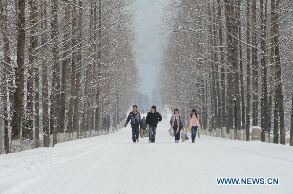 Students walk on their way back home as buses were canceled due to icy roads in Chongqing municipality, southwest China, Jan. 20, 2011. Snow in parts of the city has accumulated up to 15 centimeters high after witnessing four days of snow in a row. 