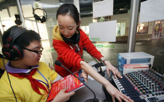 A boy from the second primary school affiliated to the Tianjin Normal University works in simulation of a radiobroadcaster during an activity of the winter camp, in Tianjin, Jan 22, 2011. Students in Tianjin are fond of spending their winter vacation in the camp to experience grown-up lives in simulation of different social roles. [Photo/Xinhua]