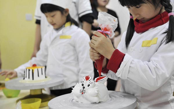 Pupils learn to make cake during the winter camp in Shenyang, Northeast China&apos;s Liaoning province, Jan 22, 2011. [Photo/Xinhua] 