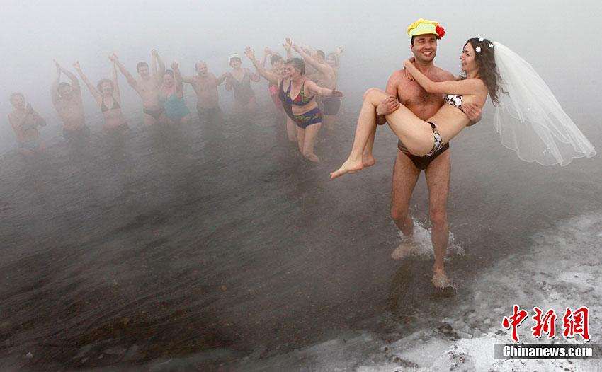 Sergey Kaunov, a member of a local winter swimmers&apos; club, and his bride Irina Kuzmenko celebrate their wedding on the bank of Yenisey River with the air temperature at about -30 degrees Celsius (-22 degree Fahrenheit) in the Russia&apos;s Siberian city of Krasnoyarsk, Jan 22, 2011. Irina does not practice winter bathing, but she did it on the day of wedding after heating up in a sauna. [Photo/Chinanews.com]