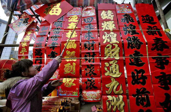 A seller arranges the Spring Festival decorations for sale at a market in Changzhi, North China&apos;s Shanxi province, Jan 23, 2010. [Photo/Xinhua]