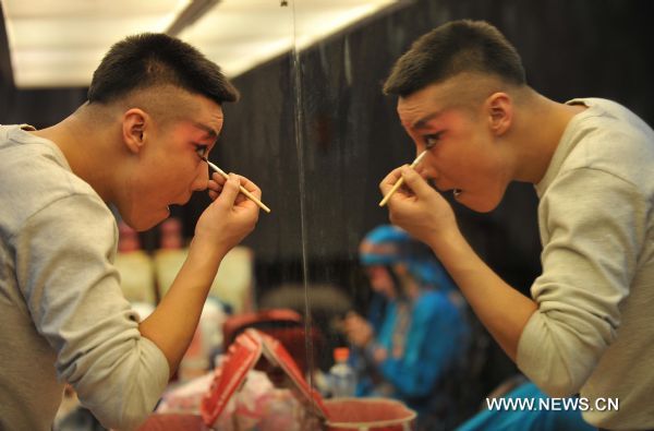 An actor prepares to perform Peking Opera in Shenyang, capital of northeast China's Liaoning Province, Jan. 23, 2011. Local Peking Opera troupe performed on Sunday for citizens free of charge, to celebrate the upcoming Chinese Lunar New Year. 
