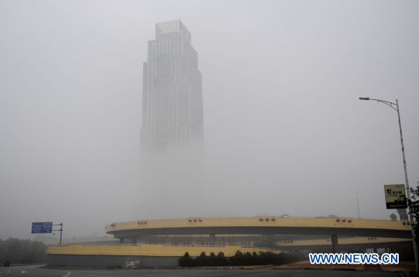 A skyscraper is enveloped in fog in Nanchang, east China&apos;s Jiangxi province on Jan. 23, 2011. Nanchang was enveloped in fog on Sunday and the visibility in part of the city reduced to 50 meters. 