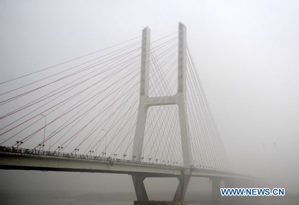 Bayi Bridge is enveloped in fog in Nanchang, east China&apos;s Jiangxi province on Jan. 23, 2011. Nanchang was enveloped in fog on Sunday and the visibility in part of the city reduced to 50 meters. 