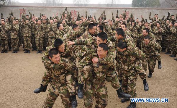 Armed policmen fight on their teammates&apos; backs during a team building exercise held for boosting mutual trust and keeping mental health in participators, in Huainan City, east China&apos;s Anhui Province, Jan. 24, 2011. [Xinhua]