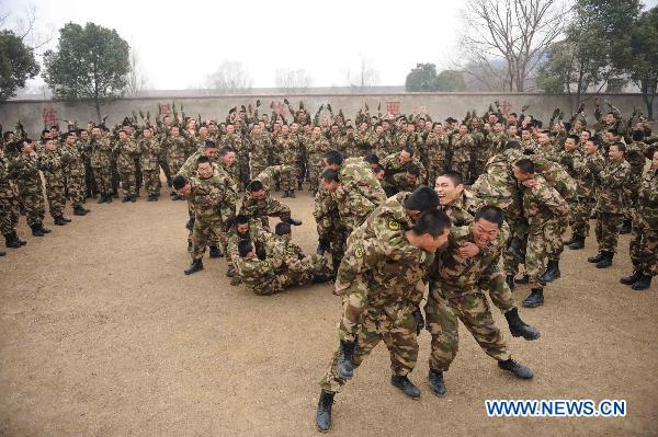 Armed policmen fight on their teammates&apos; backs during a team building exercise held for boosting mutual trust and keeping mental health in participators, in Huainan City, east China&apos;s Anhui Province, Jan. 24, 2011. [Xinhua] 