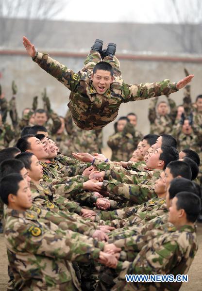 An armed policman flies into his teammates&apos; arms during a team building exercise held for boosting mutual trust and keeping mental health in participators, in Huainan City, east China&apos;s Anhui Province, Jan. 24, 2011. [Xinhua] 