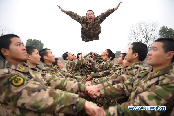 An armed policman flies into his teammates&apos; arms during a team building exercise held for boosting mutual trust and keeping mental health in participators, in Huainan City, east China&apos;s Anhui Province, Jan. 24, 2011. [Xinhua]