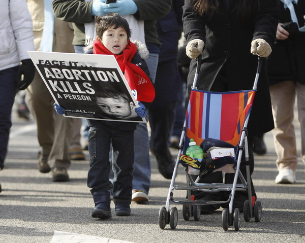 A young boy carries a pro-life banner during the annual March for Life in Washington Jan 24, 2011. [China Daily/Agencies]