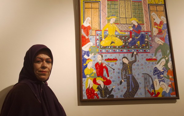 Zohre Etezadolsaltaneh,49, poses for a picture beside her painting at an exhibition in Tehran Jan 23, 2011.[China Daily/Agencies] 