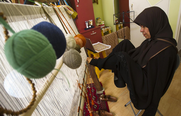 Zohre Etezadolsaltaneh, 49, weaves a kilim using her feet at her home in Tehran Jan 24, 2011.[China Daily/Agencies]