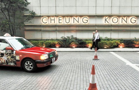 People walk past the Cheung Kong Centre in Hong Kong's financial Central District yesterday. Hong Kong's Li Ka-shing and his investment group Cheung Kong are set to make a 3.5 billion pound (US$5.6 billion) bid for E.ON's UK power distribution networks, a newspaper reported, in a move highlighting the billionaire's expansion into steady-income generating assets. [Shanghai Daily]