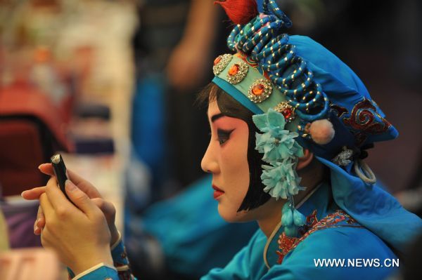 An actress waits to perform Peking Opera in Shenyang, capital of northeast China's Liaoning Province, Jan. 23, 2011. Local Peking Opera troupe performed on Sunday for citizens free of charge, to celebrate the upcoming Chinese Lunar New Year. 