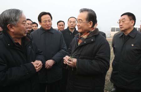 Chinese Premier Wen Jiabao (2nd R) talks to an agricultural expert about drought conditions at a field in Hebi City of central China&apos;s Henan Province, Jan. 22, 2011. Wen Jiabao wrapped up an inspection tour of the drought-hit Henan Province from Friday to Saturday, urging more efforts by local governments to ensure agricultural production threatened by the prolonged drought in many of China&apos;s grain producing areas.