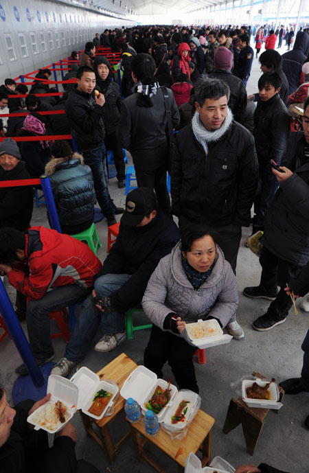 Passengers dine in the Shanghai railway station while waiting to buy train tickets on Jan 16. The Shanghai Railway Bureau has off ered improved convenience to passengers by opening more ticket windows and placing stools in the waiting area. [Photo/Xinhua]