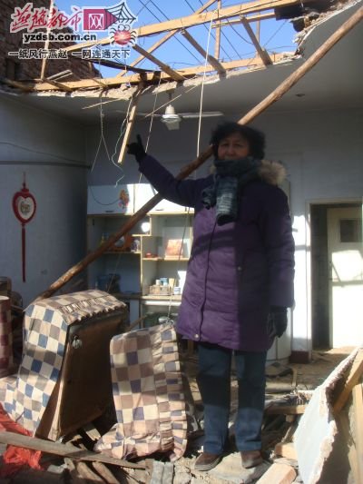 Meng Sulin stands in her destroyed house in Chunguang village, Xuanhua district of Zhangjiakou city, north China's Hebei province, Jan 23, 2011. [Photo/yzdsb.com.cn] 