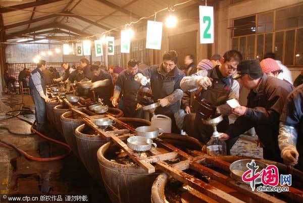 Residents line up to buy soy sauce from a time-honored brand in Zhenjiang, East China&apos;s Jiangsu province, Jan 25, 2011. The store is famous for its soy sauce and vinegar and it has been a custom to buy for the Lunar New Year by locals for more than 20 years. The staff said residents started queuing for the soy sauce from 3 am and about 10,000 will come to buy it before Jan 31. [Photo/CFP]