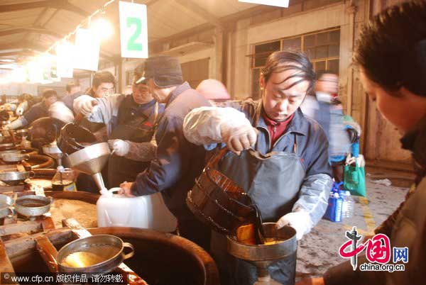 Residents line up to buy soy sauce from a time-honored brand in Zhenjiang, East China&apos;s Jiangsu province, Jan 25, 2011. The store is famous for its soy sauce and vinegar and it has been a custom to buy for the Lunar New Year by locals for more than 20 years. The staff said residents started queuing for the soy sauce from 3 am and about 10,000 will come to buy it before Jan 31. [Photo/CFP]