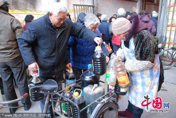 Locals transport the soy sauce they bought for the Lunar New Year on a tricycle in Zhenjiang, East China&apos;s Jiangsu province, Jan 25, 2011. [Photo/CFP]