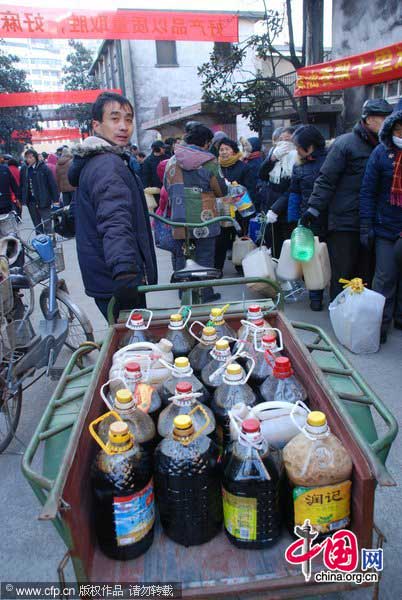 A man carries his soy sauce bought for the Lunar New Year on a tricycle in Zhenjiang, East China&apos;s Jiangsu province, Jan 25, 2011. [Photo/CFP] 