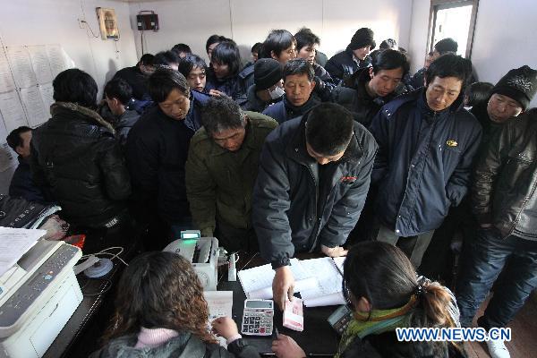 Migrant workers get their salary released by a marine engineering company in Qinhuangdao, north China&apos;s Hebei Province, Jan. 24, 2010. The company released wages of January ahead of schedule for 340 migrant workers Monday, before they going back home for Chinese Spring Festival. [Xinhua]