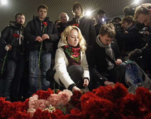 Mourners place flowers on Tuesday in Moscow&apos;s Domodedovo airport where 35 people were killed in a suicide bombing on Jan 24, 2011. [China Daily/Agencies]