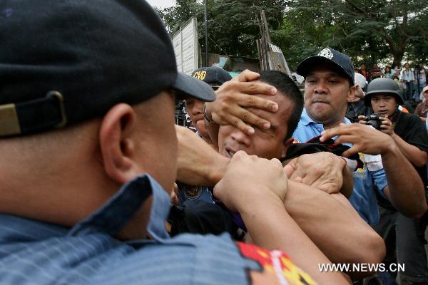 Policemen arrest a resident during the demolition of shanties in San Juan City, north of Manila, Jan. 25, 2011. Some 40 people were injuried during the violent demolition that will affect more than 1,000 families in the area. [Xinhua] 