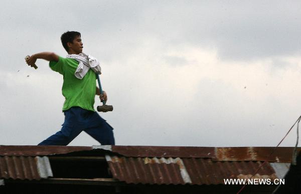 A member of a demolition team throws a bottle against residents during the demolition of shanties in San Juan City, north of Manila, Jan. 25, 2011. Some 40 people were injuried during the violent demolition that will affect more than 1,000 families in the area. [Xinhua]