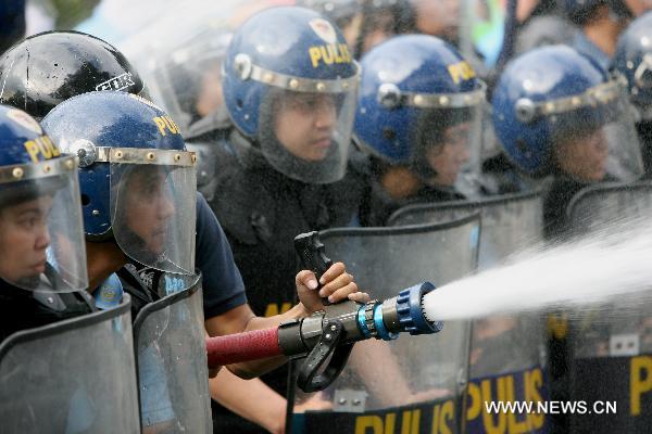 Anti-riot policemen fire a water gun against residentduring the demolition of shanties in San Juan City, north of Manila, Jan. 25, 2011. Some 40 people were injuried during the violent demolition that will affect more than 1,000 families in the area. [Xinhua]