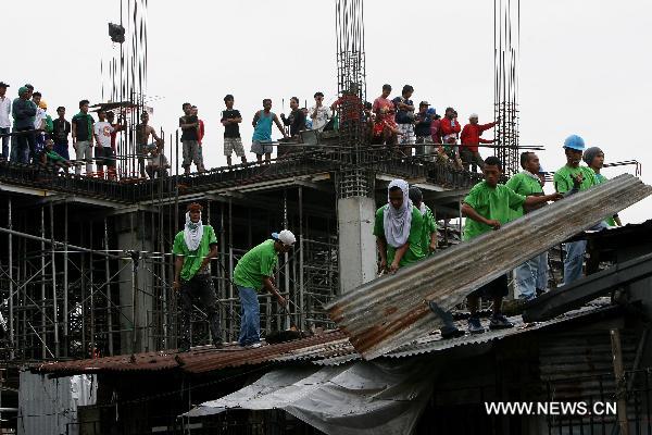 Demolition teams dismantle a shanty during the demolition of shanties in San Juan City, north of Manila, Jan. 25, 2011. Some 40 people were injuried during the violent demolition that will affect more than 1,000 families in the area. [Xinhua]