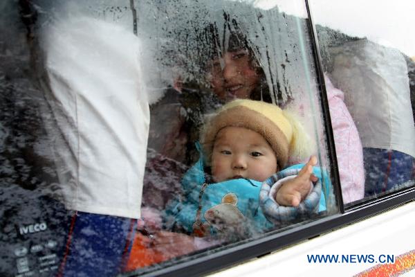 A child waits in a vehicle on the frost-stricken No. 303 Provincial Highway for the recovery of traffic in Hami, northwest China&apos;s Xinjiang Uygur Autonomous Region, Jan. 25, 2011. Snow hit the city of Hami on Tuesday, causing traffic congestion on the frozen segment of the highway. [Xinhua]