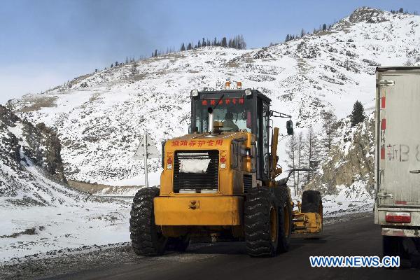 A snow remover cleans the ice and snow on the No. 303 Provincial Highway in Hami, northwest China&apos;s Xinjiang Uygur Autonomous Region, Jan. 25, 2011. Snow hit the city of Hami on Tuesday, causing traffic congestion on the frozen segment of the highway.