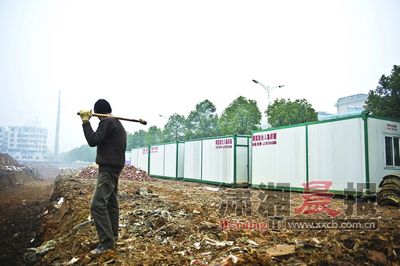 A man stands on a construction site in front of the container homes in Yuelu district of Changsha, Central China's Hunan province. [Photo/Xiaoxiang Morning Herald]