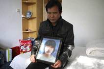 In this photo taken on Oct 29, 2010, Chen Guangqian holds a portrait of his daughter Chen Xiaofeng at a hotel room in Baoding in North China's Hebei province. The young woman was killed by a speeding car driven by Li Qiming, who will go to trial on Wednesday.