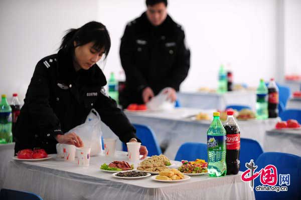 Police officers prepare dinner for prisoners and their family on Jan 25 at Haidian detention house in Beijing. [Photo/CFP]