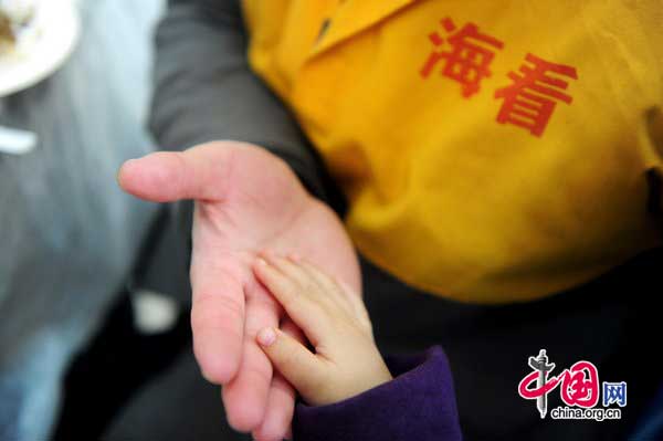 A prisoner plays with a child on Jan 25, at Haidian detention house in Beijing. [Photo/CFP]