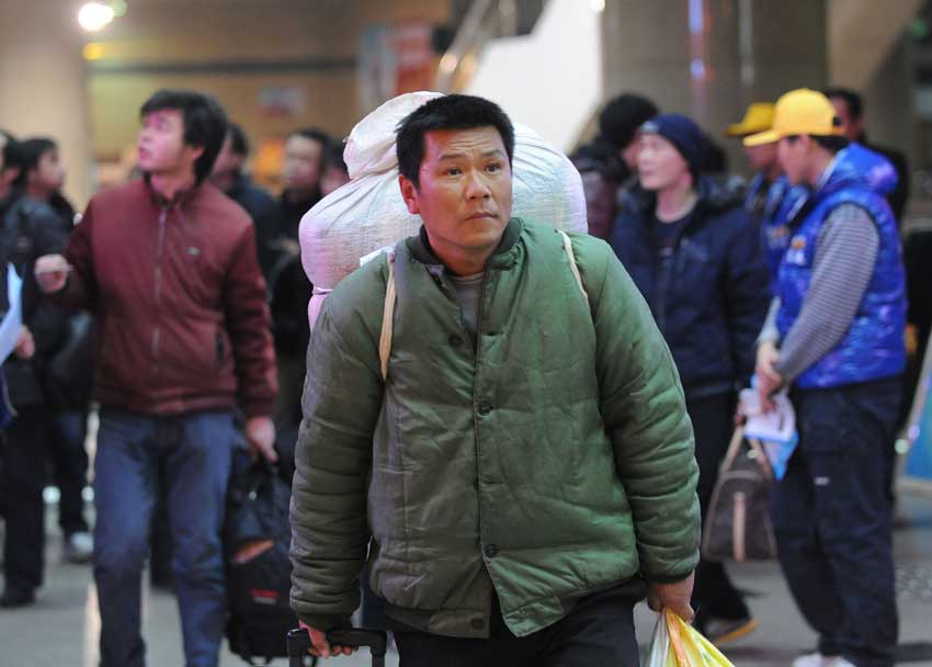 Geng Libo, a migrant worker from Southwest China&apos;s Yunnan province, waits for his train at a railway station in Zhengzhou, Central China&apos;s Henan province, Jan 26, 2011. January 19 marked the beginning of the annual Spring Festival travel rush, with an expected 2.56 billion passenger trips in the coming 40 days. [Photo/Xinhua]