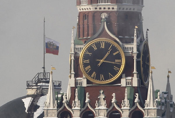 The Russian national flag flutters at half mast behind the Spasskaya Tower of the Kremlin during a day of mourning for victims of Monday&apos;s bomb explosion, in Moscow Jan 26, 2011. [China Daily/Agencies]