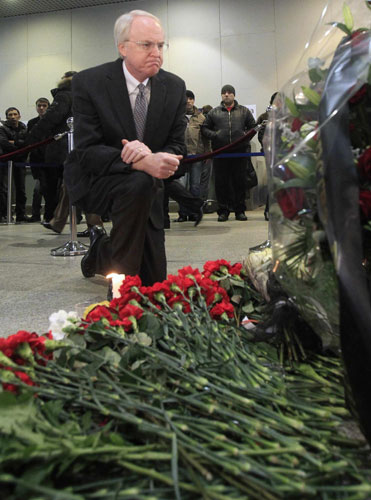 US Ambassador to Russia John Beyrle observes a minute of silence as he flowers in memory of those killed in Monday&apos;s bomb explosion at Moscow&apos;s Domodedovo airport Jan 26, 2011. [China Daily/Agencies]