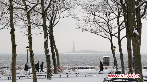 Pedestrians walk in the snow at the Battery Park in New York, the United States, Jan. 26, 2011. The snow started falling here around 8 a.m. Wednesday morning (13:00 GMT) with the National Weather Service issuing a winter storm warning in effect from 10 a.m. Wednesday until 6 a.m. Thursday. [Xinhua] 