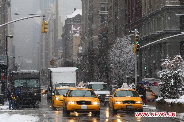 Taxis run slowly in the snow in Manhattan, New York, the United States, Jan. 26, 2011. 