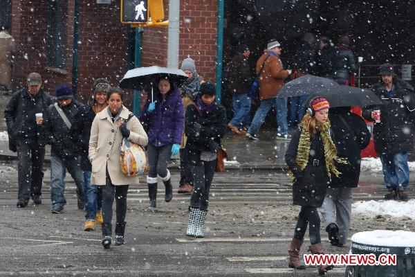 Pedestrians walk in the snow in Manhattan, New York, the United States, Jan. 26, 2011. 