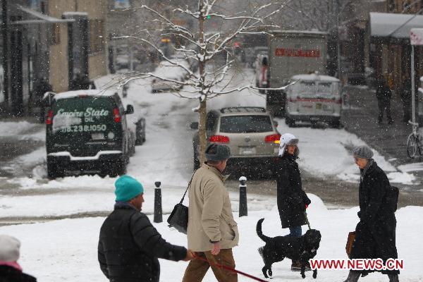 Pedestrians walk in the snow in Manhattan, New York, the United States, Jan. 26, 2011. 