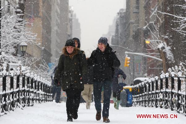 Pedestrians walk in the snow in Manhattan, New York, the United States, Jan. 26, 2011.