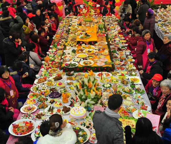 Residents attend a grand feast held at the Baibuting Community in Wuhan, capital of Central China&apos;s Hubei province, Jan 27, 2011. Community residents brought more than 8,000 self-cooked dishes to enjoy together on Thursday, to celebrate the upcoming traditional Spring Festival. It sets a new Guinness World Record by showing the most dishes in multiple venues. [Photo/Xinhua]