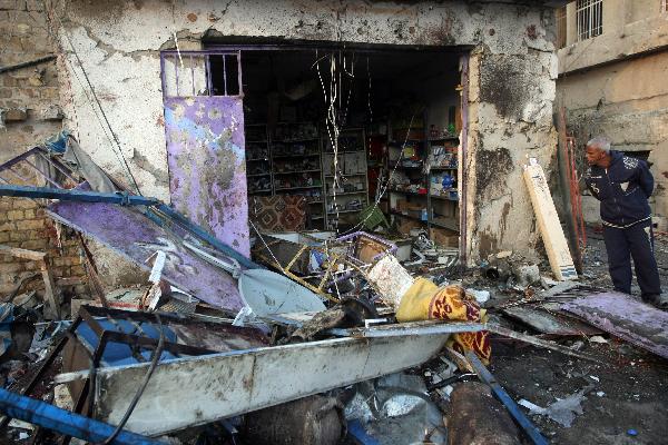 A man checks a shop devastated by the bombing in Baghdad's northwestern neighborhood of Shula. Up to 48 people were killed and 121 others were wounded in a car bomb explosion at a funeral tent in northwestern Baghdad on Thursday. [Xinhua]