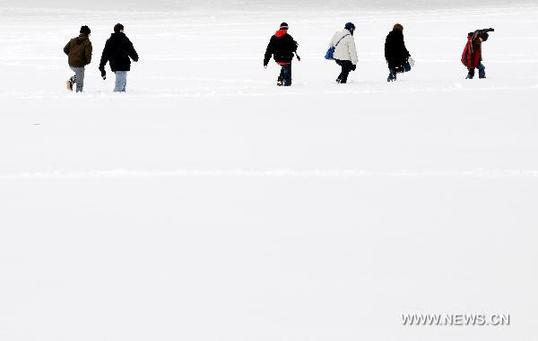 People walk in the snow-covered Central Park in New York, the United States, Jan. 27, 2011. New York Mayor Michael Bloomberg announced on Thursday that the city had experienced the snowiest January in history after a thick blanket of snow covered the city.