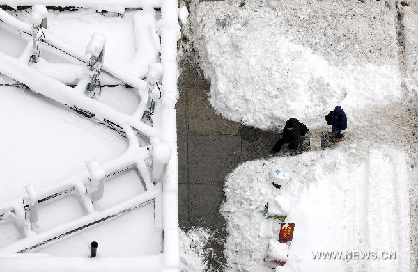 People walk on a snow-covered road in New York, the United States, Jan. 27, 2011. New York Mayor Michael Bloomberg announced on Thursday that the city had experienced the snowiest January in history after a thick blanket of snow covered the city. 